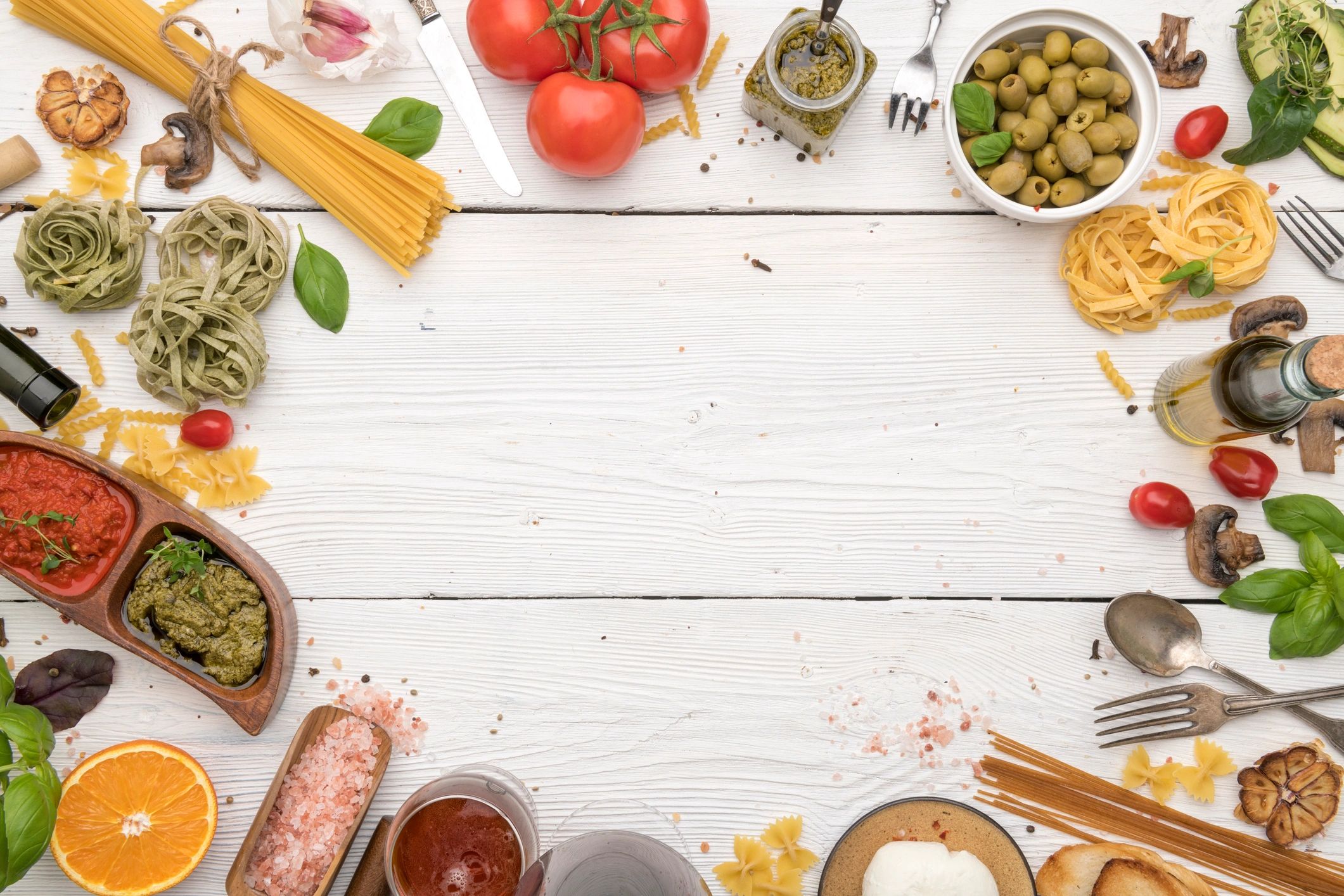 Italian food and ingredients arranged around a rustic table with copy space