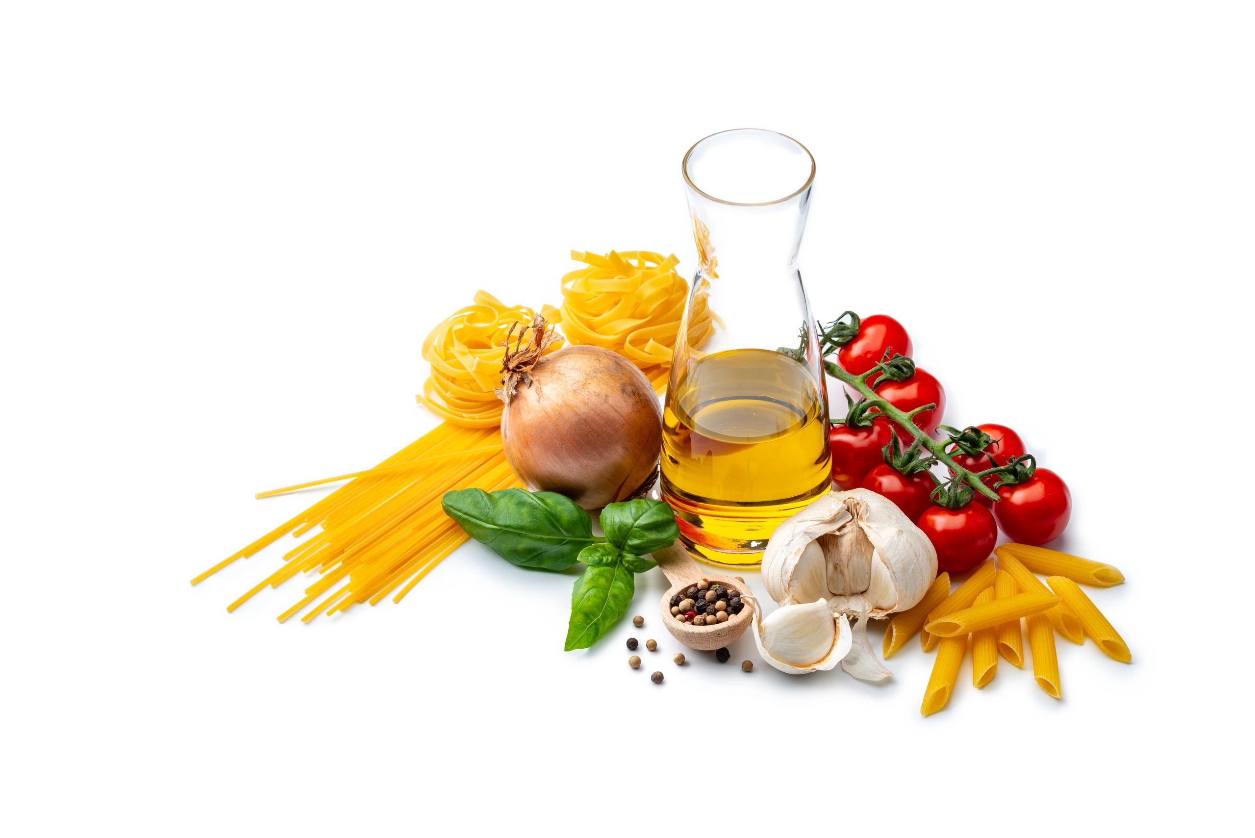Pasta and fresh ingredients arranged on white background